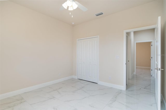 unfurnished bedroom with a ceiling fan, visible vents, baseboards, marble finish floor, and a closet