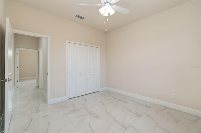 unfurnished bedroom featuring a ceiling fan, visible vents, baseboards, marble finish floor, and a closet