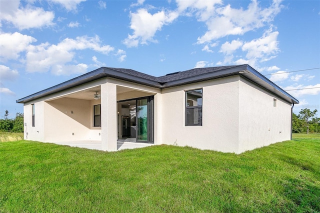 back of house featuring a patio, a yard, a ceiling fan, and stucco siding