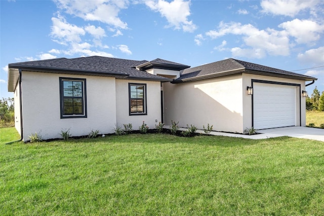 prairie-style home with a front yard, an attached garage, and stucco siding