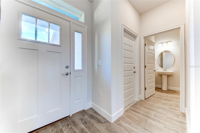 foyer entrance with light hardwood / wood-style flooring and sink