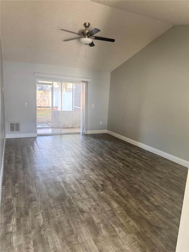 spare room featuring a textured ceiling, ceiling fan, dark wood-type flooring, and lofted ceiling