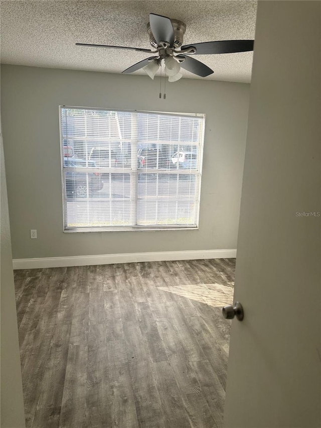 empty room with a textured ceiling, a wealth of natural light, and ceiling fan