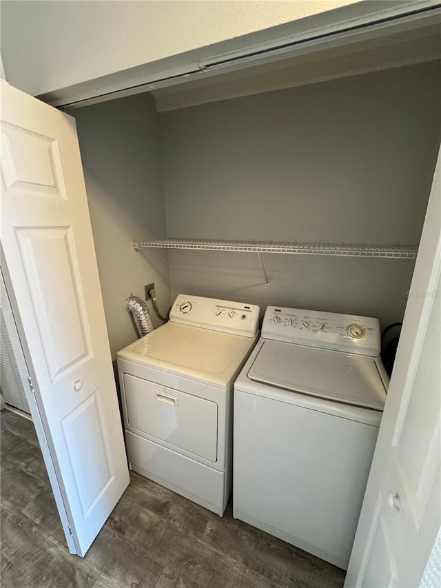 clothes washing area with washing machine and dryer and dark wood-type flooring