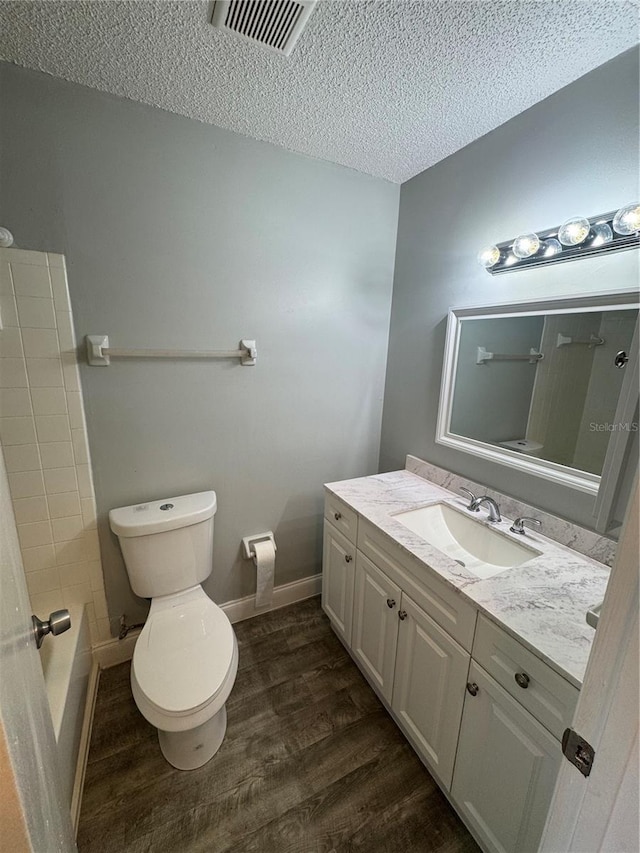 bathroom with vanity, hardwood / wood-style floors, a textured ceiling, and toilet