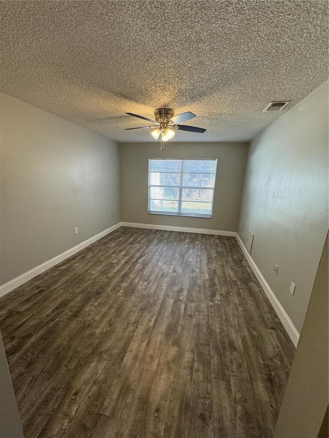 spare room with a textured ceiling, ceiling fan, and dark wood-type flooring