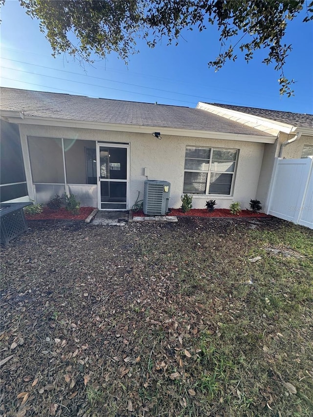 rear view of property with a sunroom and central AC unit