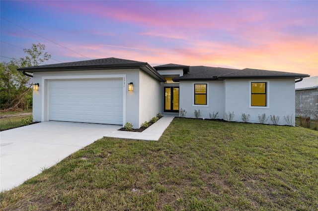 view of front of property with an attached garage, a front lawn, concrete driveway, and stucco siding