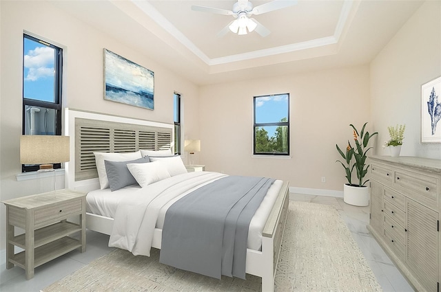 bedroom with ceiling fan and a raised ceiling