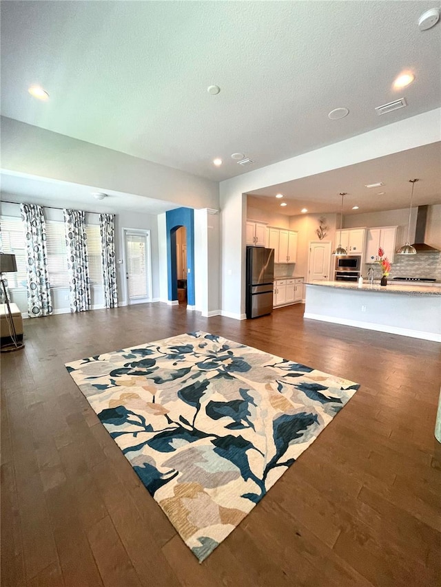 living room featuring a textured ceiling and dark hardwood / wood-style flooring