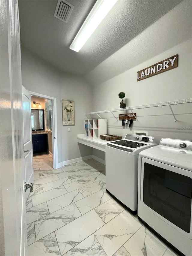 clothes washing area featuring independent washer and dryer and a textured ceiling