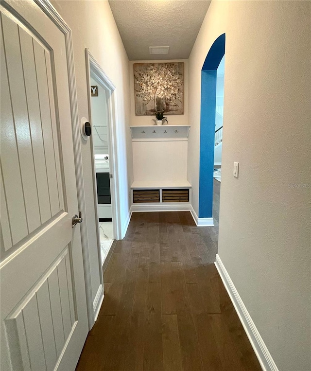 hallway featuring dark hardwood / wood-style flooring and a textured ceiling