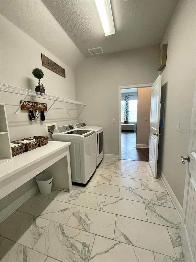 clothes washing area featuring independent washer and dryer and a textured ceiling