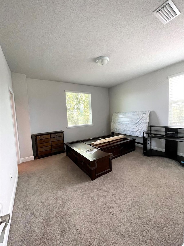 unfurnished bedroom featuring light colored carpet and a textured ceiling