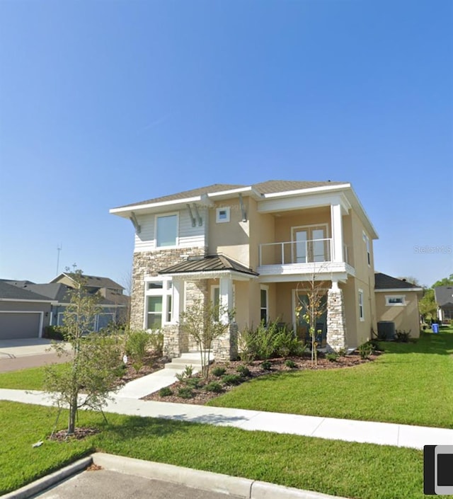 view of front of home with a balcony and a front lawn