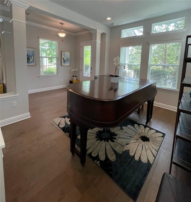 misc room featuring decorative columns, ornamental molding, and dark hardwood / wood-style floors