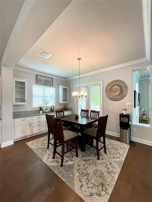 dining room with dark hardwood / wood-style flooring, crown molding, a textured ceiling, and an inviting chandelier