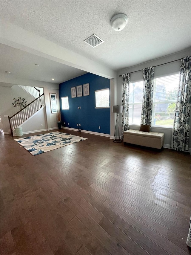 interior space featuring dark wood-type flooring and a textured ceiling