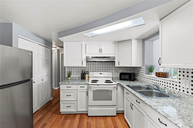 kitchen featuring white electric range, white cabinetry, sink, stainless steel refrigerator, and range hood