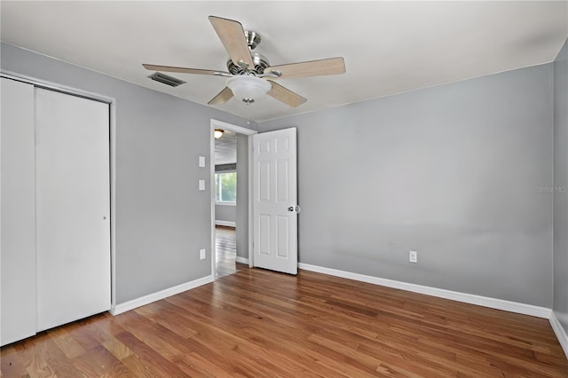 unfurnished bedroom featuring ceiling fan, a closet, and light wood-type flooring