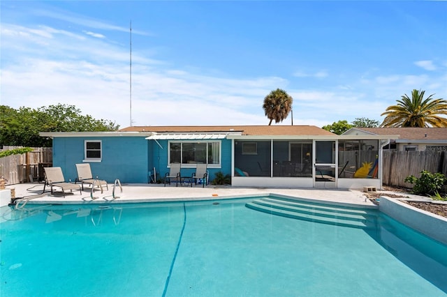 view of pool with a sunroom and a patio