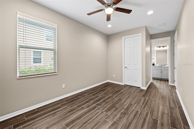 unfurnished bedroom with ceiling fan, a closet, dark hardwood / wood-style floors, and ensuite bathroom