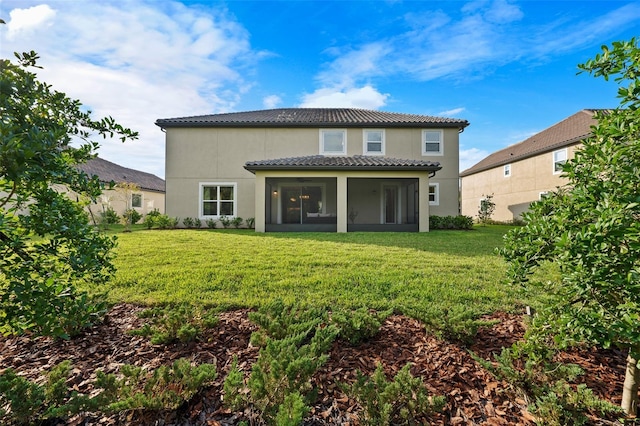 rear view of house with a sunroom and a yard