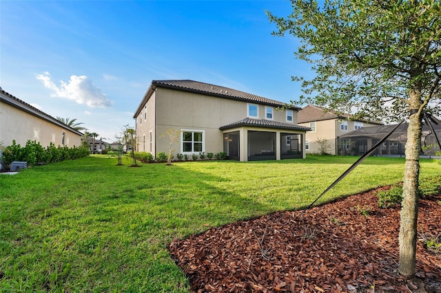 back of property with a sunroom and a yard