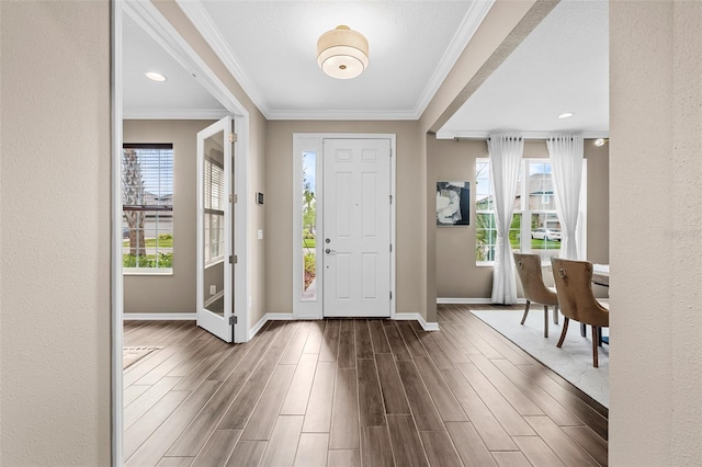 entryway featuring baseboards, a textured wall, ornamental molding, and dark wood-style flooring