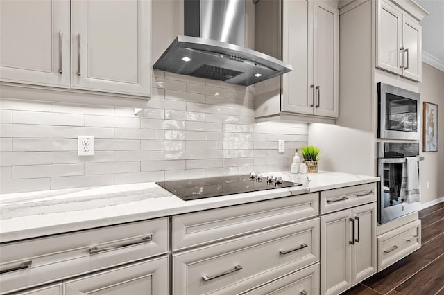 kitchen with tasteful backsplash, light stone countertops, stainless steel appliances, wall chimney range hood, and dark wood-type flooring