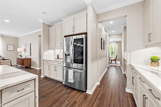 kitchen featuring dark wood-style flooring, stainless steel fridge, light stone countertops, ornamental molding, and white cabinetry