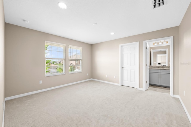 unfurnished bedroom featuring baseboards, visible vents, recessed lighting, and light colored carpet