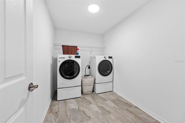 washroom featuring baseboards, laundry area, and washer and dryer