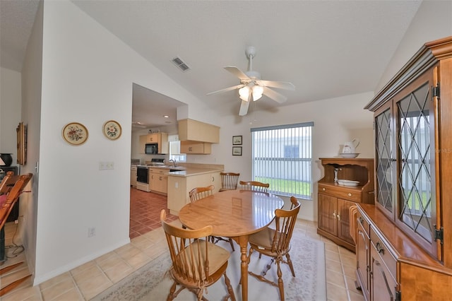 dining area featuring sink, light tile patterned flooring, lofted ceiling, and ceiling fan