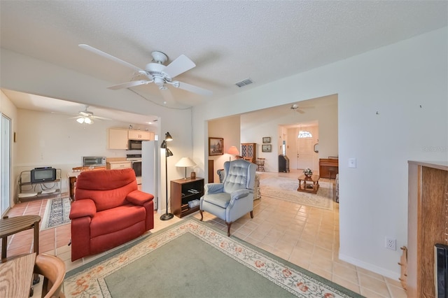 tiled living room with a textured ceiling and ceiling fan