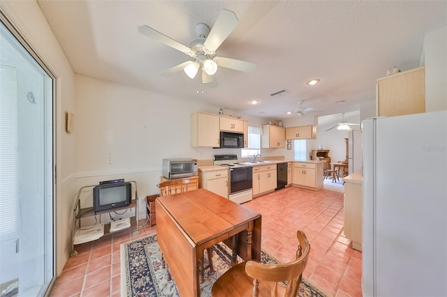 kitchen featuring light tile patterned flooring, black appliances, ceiling fan, and cream cabinets