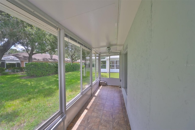 unfurnished sunroom featuring ceiling fan