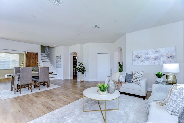 20131 Nob Oak Ave, Tampa, FL 33647 - living room featuring arched walkways, stairway, wood finished floors, and baseboards