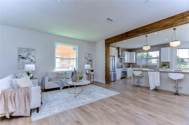 20131 Nob Oak Ave, Tampa, FL 33647 - living room featuring light wood-style floors and beamed ceiling