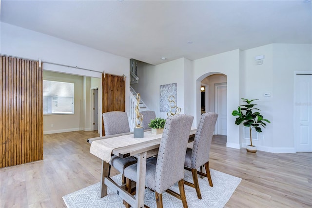 20131 Nob Oak Ave, Tampa, FL 33647 - dining area featuring arched walkways, stairs, light wood-type flooring, and baseboards