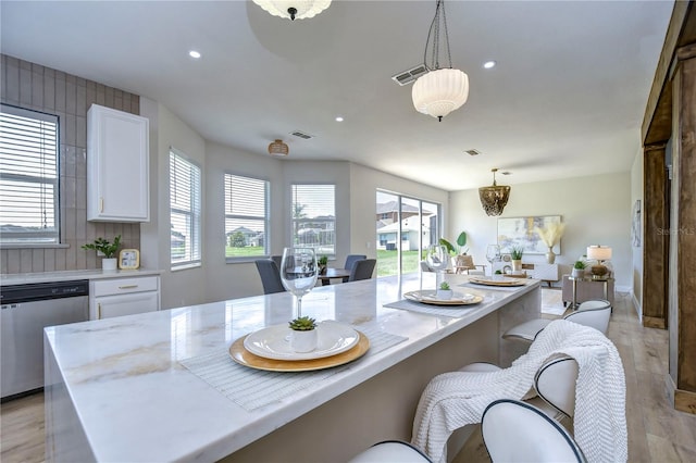 kitchen with white cabinetry, stainless steel dishwasher, and pendant lighting