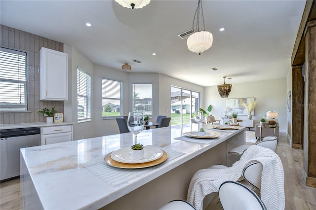20131 Nob Oak Ave, Tampa, FL 33647 - kitchen with stainless steel dishwasher, white cabinets, a kitchen bar, recessed lighting, and light wood-style floors