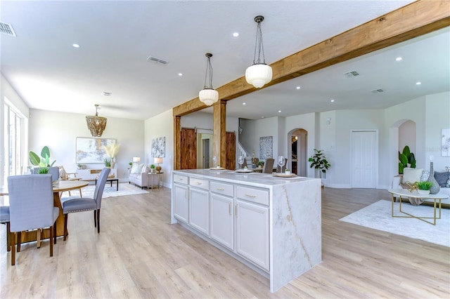 20131 Nob Oak Ave, Tampa, FL 33647 - kitchen with arched walkways, open floor plan, white cabinetry, recessed lighting, and light wood-style flooring