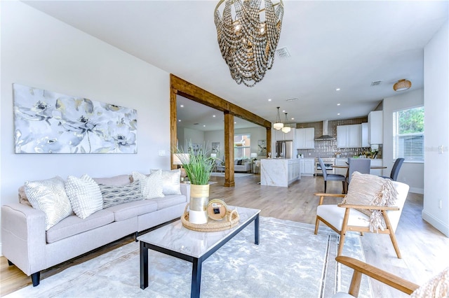 living room featuring a chandelier and light hardwood / wood-style floors