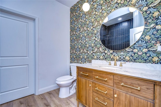 bathroom with vanity, toilet, and hardwood / wood-style floors