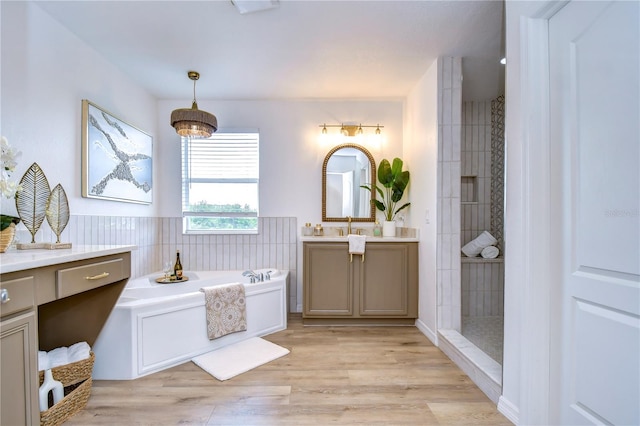 bathroom featuring hardwood / wood-style flooring, vanity, and separate shower and tub