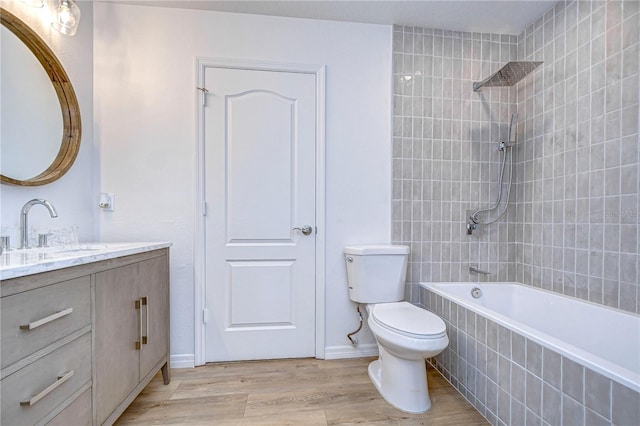 full bathroom featuring vanity, wood-type flooring, toilet, and tiled shower / bath