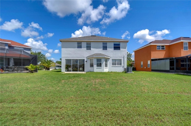 rear view of house featuring a yard, a lanai, and central air condition unit