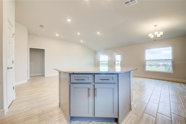 kitchen featuring gray cabinetry, a center island, vaulted ceiling, and pendant lighting