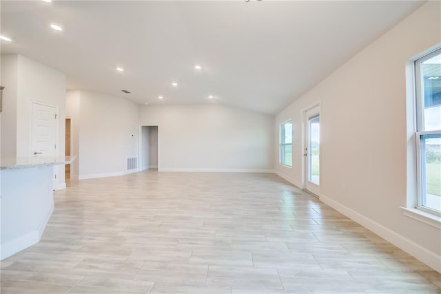 unfurnished living room with vaulted ceiling and light hardwood / wood-style flooring